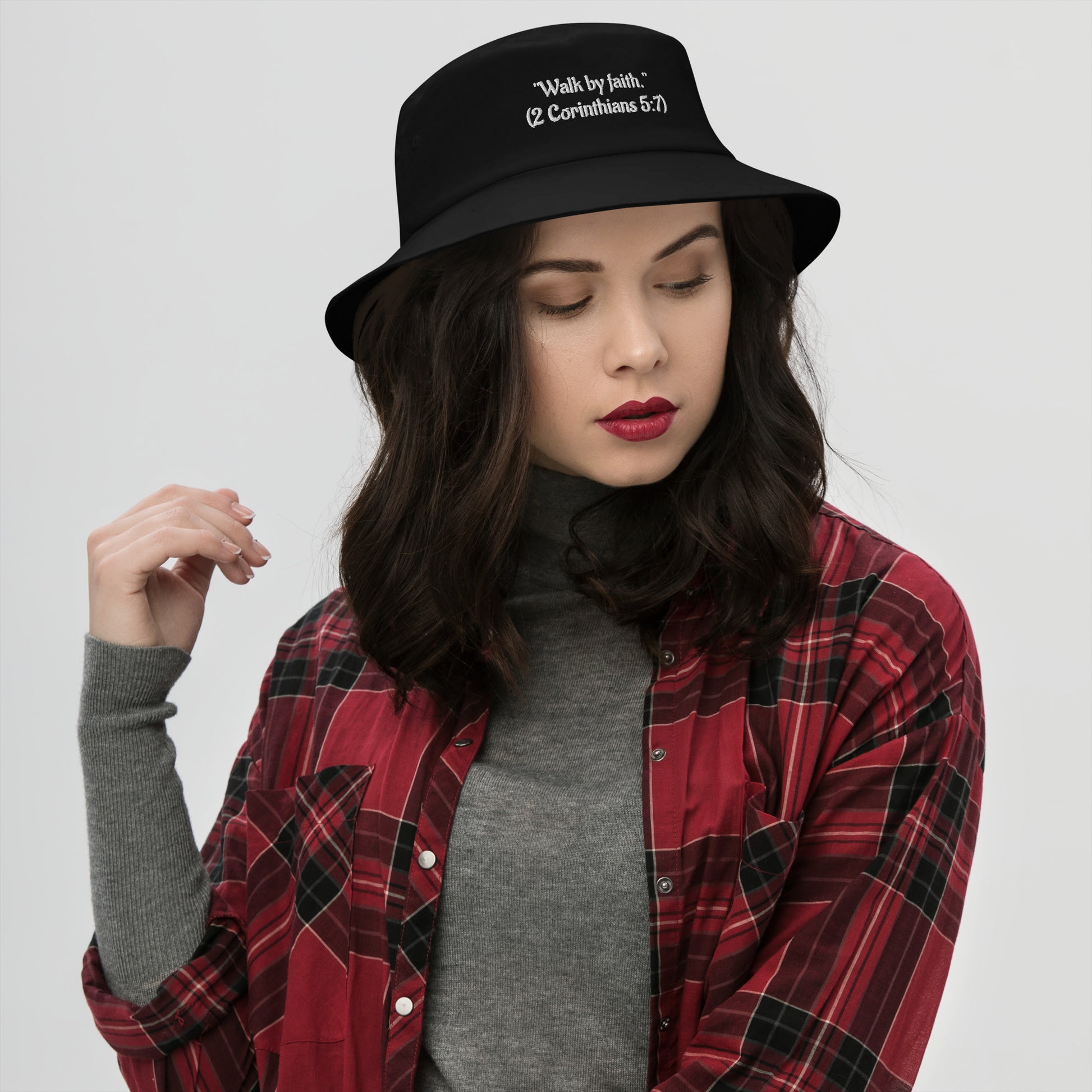 Woman wearing black Christian bucket hat with Walk by Faith embroidered on front
